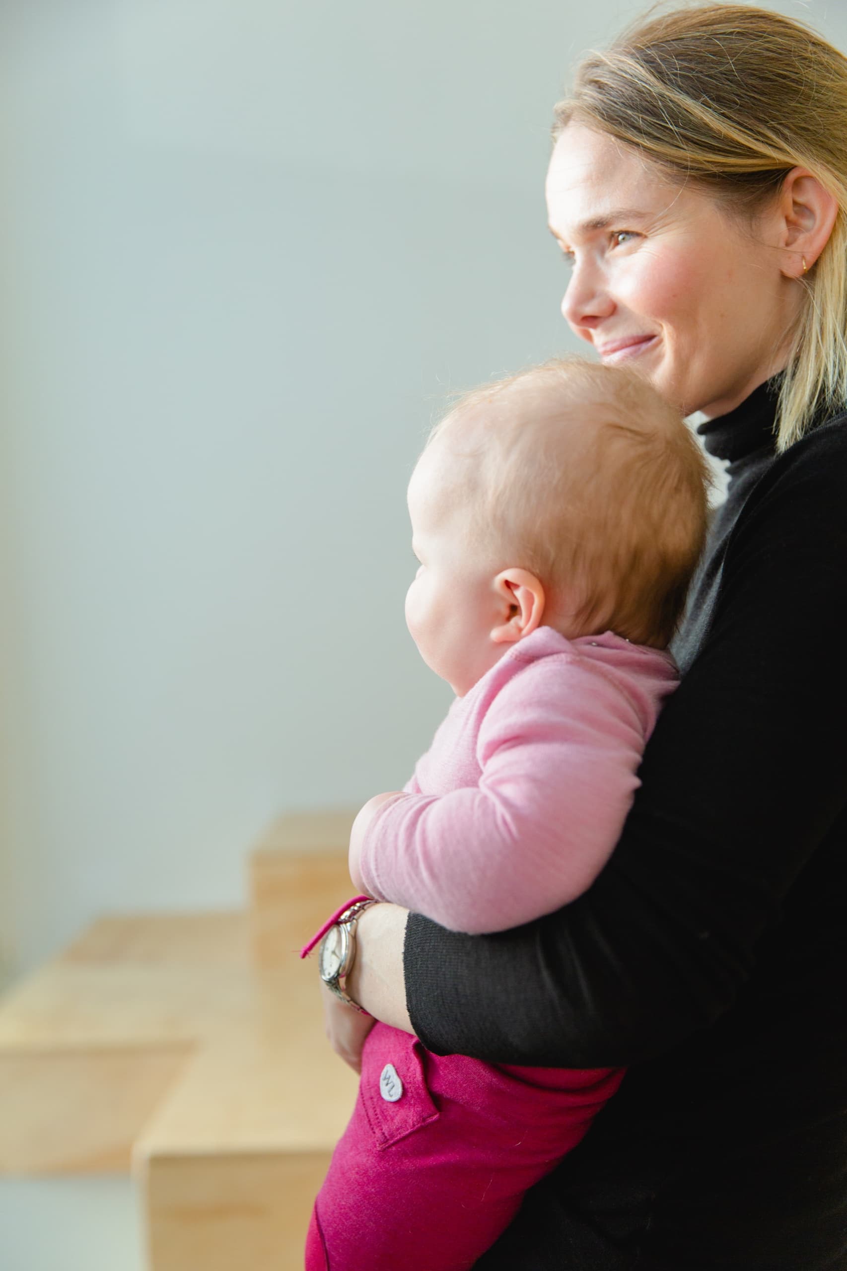 Mor holder babyen sin tett inntil seg hos Lille Lab