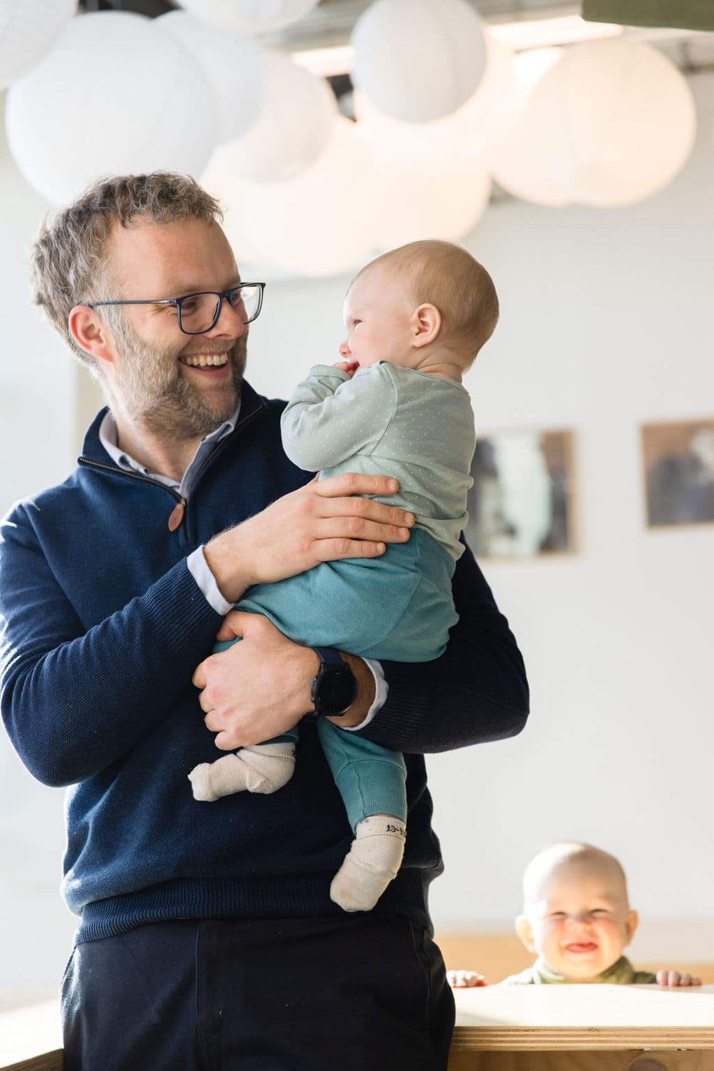 Pappa holder en leende baby hos Lille Lab